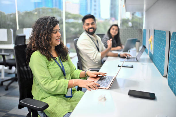 Office colleagues are actively working in a modern Indian office environment. Colleagues are seen discussing and enjoying light-hearted moments while working in the office, reflecting a positive and dynamic work culture. Ideal for teamwork, innovation, and a lively office environment.